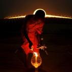 Un monje budista enciende una vela en el templo Wat Phra Dhammakaya durante la ceremonia del Makha Bucha Day en la provincia de Pathum Thani, en el norte de Bangkok (Tailandia).