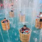 Varios turistas sentados en cubos de hielo comen pimientos en una fuente durante una competición en Hangzhou, en la provincia de Zhejiang (China). Se trata de sentir frío y calor (la temperatura es de 40ºC) al mismo tiempo.