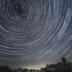 Satélites, aviones y cometas cruzan el cielo nocturno bajo las estrellas que parecen rotar sobre el Castillo de Corfe el 12 de agosto en Reino Unido. El fenómeno de las Perseidas ocurre una vez al año.