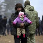Un hombre abraza a una ni&ntilde;a en un campamento improvisado en la frontera entre Bielorrusia y Polonia, en la regi&oacute;n de Grodno, ayer domingo.