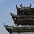 Unos acróbatas de ocho años caminan sobre la cuerda floja en un edificio tradicional chino durante una actuación para los turistas en Anhui (China).