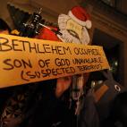 2011: pancarta de la protesta Occupy DC en la que se ve a Marx como Pap&aacute; Noel, denunciando la ocupaci&oacute;n de Bel&eacute;n.