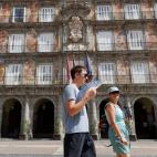 Unos turistas pasean por la Plaza Mayor de Madrid.