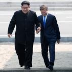 Los l&iacute;deres coreanos cruzan la frontera entre sus pa&iacute;ses cogidos de la mano.