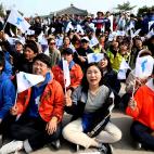 Un grupo de surcoreanos reacciona mientras contempla el encuentro entre Kim y Moon en una pantalla.