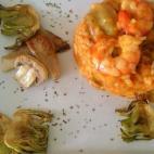 Además de gambas al curry, lleva alcachofas, setas, cebolla, ajos y sofrito de tomate. Puedes ver aquí la receta completa.