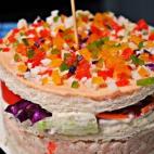 Está hecho con bonito, cebolla picada, palitos de surimi, mayonesa, tomate, lechuga, salsa rosa, pimiento rojo, verde, amarillo y pan de molde. Se prepara en menos de 20 minutos. Puedes ver aquí cómo hacerlo.