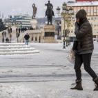 Una mujer camina por la plaza principal cubierta de nieve y hielo en Skopje, Macedonia.