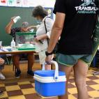 Un hombre cargado con nevera y sombrilla de playa espera para ejercer su derecho al voto en el colegio Virgen del Mar de Almería hoy domingo 19 de junio cuando se han constituido una totalidad de 10.189 mesas electorales para los duodécimos co...