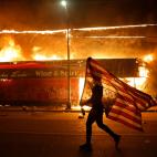Un manifestante porta la bandera de EEUU en Minneapolis, durante las protestas por la muerte de George Floyd, en Minneapolis.