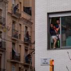 Una familia asomada al balc&oacute;n durante el confinamiento, en Barcelona.