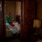 Josefa Ribas, de 86 a&ntilde;os, encamada y enferma de demencia, atendida por la enfermera Laura Vald&eacute;s en su casa de Barcelona, el pasado abril.