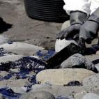 Voluntarios recogen el combustible que ha llegado en las últimas horas a la playa de Venegueras.