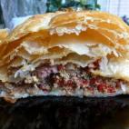 Se prepara con carne picada, tacos de jamón, pimiento rooj, huevo duro, aceitunas, foie gras, un poco de leche y masa de hojaldre. Consulta aquí la receta completa.