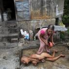 Tang Thi Thang baña a su hijo Doan Van Quy ante su vivienda en Truc Ly. El padre del menor fue militar, destinado en zonas donde se empleó el agente. Los dos hijos de la familia nacieron con discapacidades.