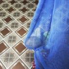 Lai Van Manh descansa en su cama, con su padre Lai Van Bien al fondo, recibiendo a unos vecinos, en Tuong An. El progenitor fue un agente de Inteligencia afectado por el agente, que ha tenido dos hijos con discapacidades varias.