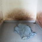 Doan Thi Hong Gam, de 38 años, que sifría un importante daño cerebral, se cubre a sí misma con una sábana en la habitación vacía en la que suele estar, en su casa de Thai Bin. Su padre la ha confinado allí por su comportamiento violento.