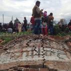 Vecinos esperan ayuda fuera de sus casas en Katmandú.