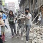 Un herido, atendido por vecinos en la capital de Nepal.