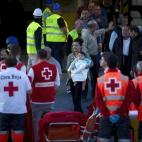 Pasajeros a su llegada al puerto de Palma de Mallorca, mientras trabajadores de la Cruz Roja esperan por si hay heridos.