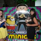 Dos invitadas posan junto al cartel de la nueva película de Los Minions