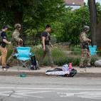 Militares pasan entre los objetos de las personas que disfrutaban del desfile del 4 de julio.