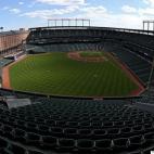 Los Baltimore Orioles y los White Sox de Chicago se levantan para recibir el himno nacional en un estadio vacío en Camden Yards el 29 de abril de 2015 en Baltimore. Debido a las protestas por el arresto y la muerte de Freddie Gray, ambos equipo...