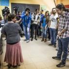 Pablo Iglesias, líder de Podemos, bromea con una señora antes de votar en Vallecas, Madrid.