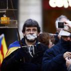 Uno de los asistentes en la concentración en la plaza de Sant Jaume porta una urna enjaulada.