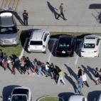 Llevan los brazos apoyados en los hombros del que camina delante, organizados as&iacute; por los agentes.