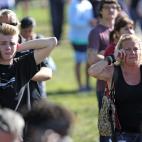 Un joven y una mujer adulta llaman a sus seres queridos mientras esperan noticias de su familia.