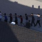 Un grupo de estudiantes son conducidos por agentes de Polic&iacute;a fuera del recinto escolar.