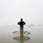 El surfista Reed Platenious sujeta una tabla durante el campeonato de surf canadiense en Tofino, Canadá.