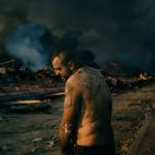 Un hombre herido se encuentra cerca del lugar de la gran explosión en el puerto de Beirut, Líbano, mientras los bomberos trabajan para apagar los incendios, el 4 de agosto.