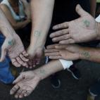 El número en la fila de espera para comprar alimentos es marcado en los brazos de los venezolanos.