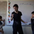 Abu Yassin, combatiente de la oposición, enseña a los niños en la ciudad de Alepo (Siria).