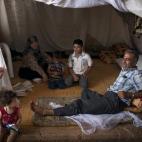 Una familia de refugiados sirios descansan en el campo de refugiados de la ciudad de Azaz (Siria).