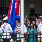 Varios oficiales izan la bandera cubana en la que será la embajada del país en Washington, Estados Unidos.