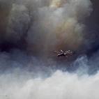 Un helicópetro intenta sofocar un incendio en el suburbio de Karea en Atenas (Grecia).