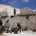 Rebeldes sirios cargan un camión en la ciudad de Alepo.