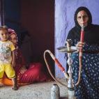 Hajja Sameeha fuma shisha en su casa en Nag' Besion, su hija Mona y su nieto Yaseen están sentados junto a ella. Estas casas antiguas de Nubia en Asuán Gharb, se caracterizan por tener un gran patio abierto en el centro, comunicado con más de...