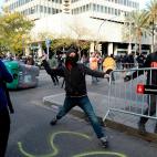 Uno de los manifestantes tira piedras durante las protestas.