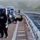Varios conductores esperan fuera de sus veh&iacute;culos durante la retenci&oacute;n que ha provocado en la autopista AP-7 el corte que han realizado grupos independentistas.