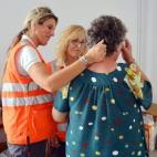 Dos técnicas de la Cruz Roja intentan consolar a una de las vecinas evacuadas.