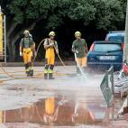Miembros del IBANAT limpian las calles del fango acumulado tras el desbordamiento del torrente.