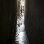 Regando con agua las calles para refrescar, en el campo de Shatti.
