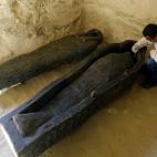 Un arque&oacute;logo egipcio trabaja en la restauraci&oacute;n de los sarc&oacute;fagos descubiertos dentro de una tumba en la Necr&oacute;polis de Assassif, en Luxor.