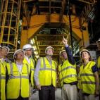 Porque el responsable que le explica la obra le señala y, claro, no va a hacerle el feo de no mirar.