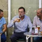 Tanto ajetreo bien merecía una cerveza fría en compañía del alcalde de Celanova y un joven con polo azul mientras los fotógrafos, reflejados en el cristal, se afanan en captar el momento.