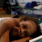 Una mujer intenta descansar en los centros que se han preparado para acoger a los damnificados.